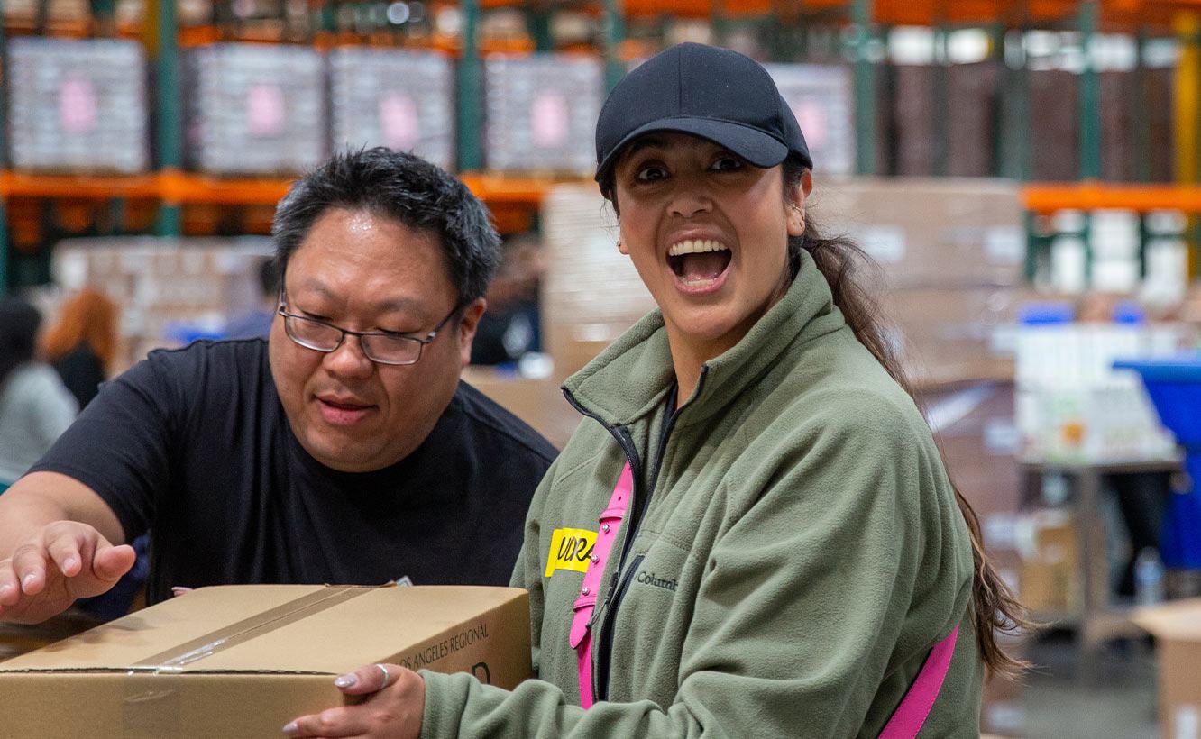 Team smiling while packing boxes